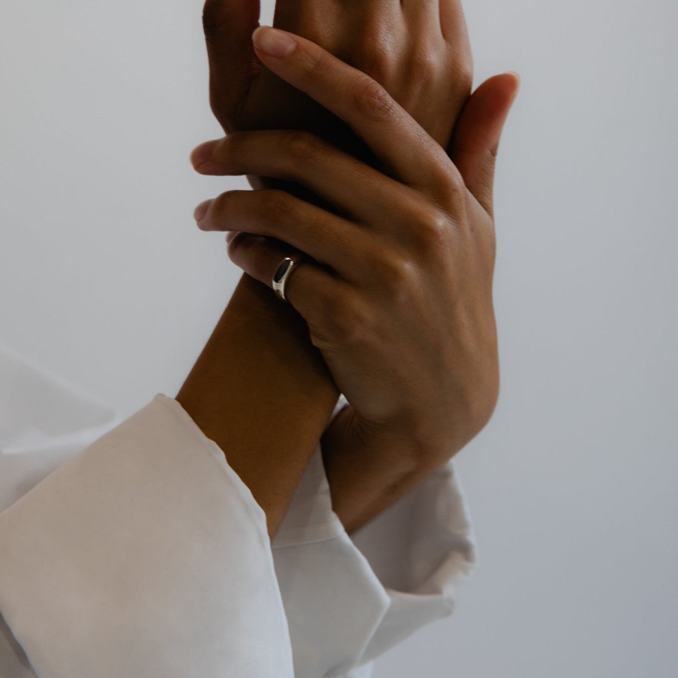 silver signet ring on hands