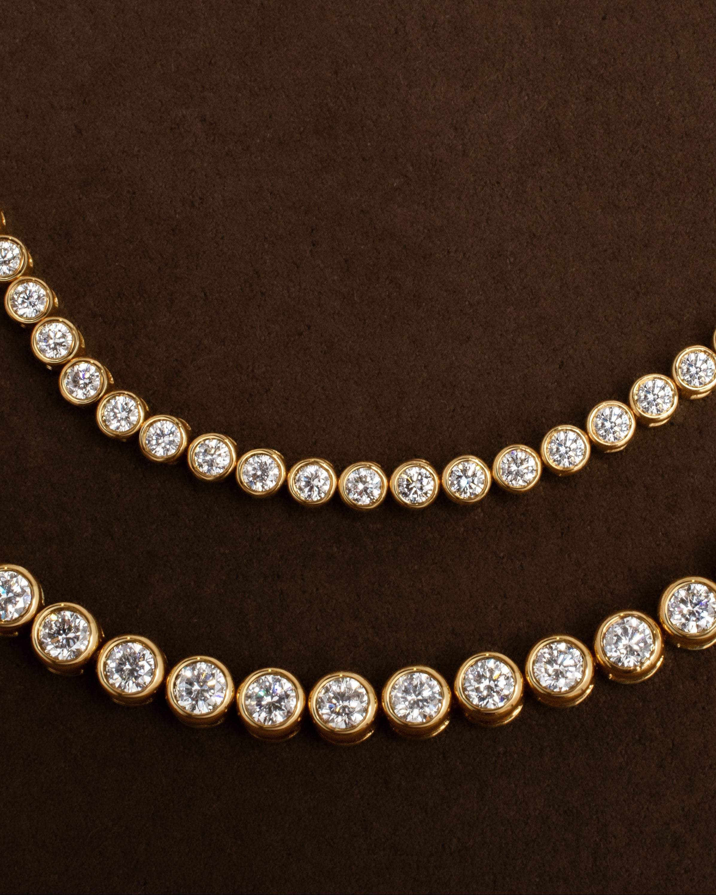 Gold tennis bracelets with round bezel set diamonds