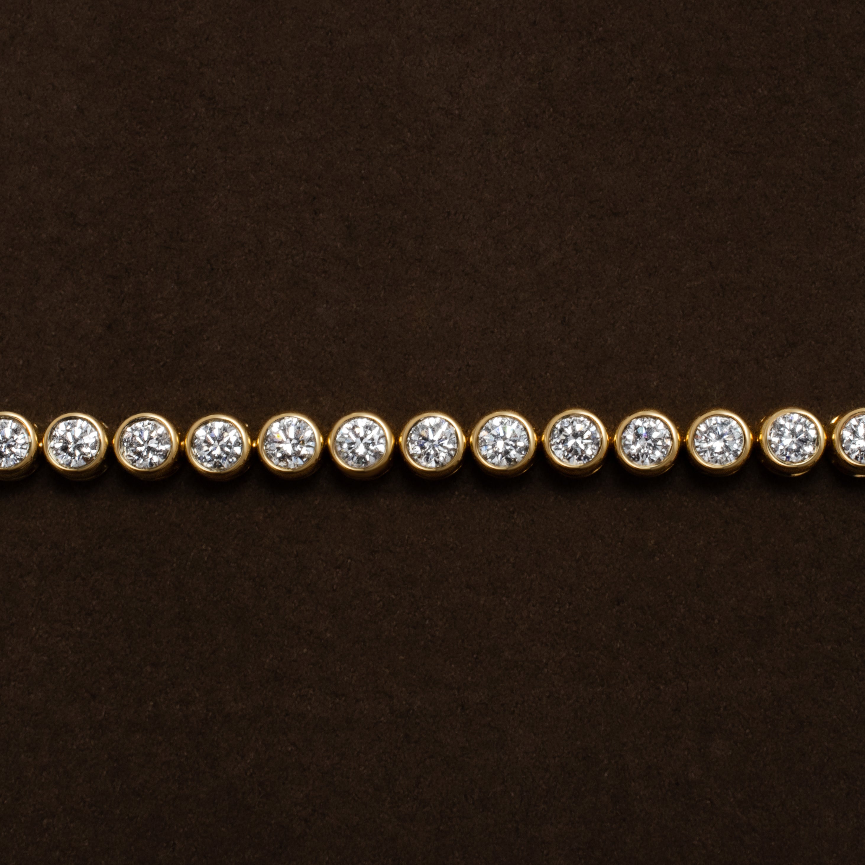 Gold tennis bracelet with bezel set diamonds