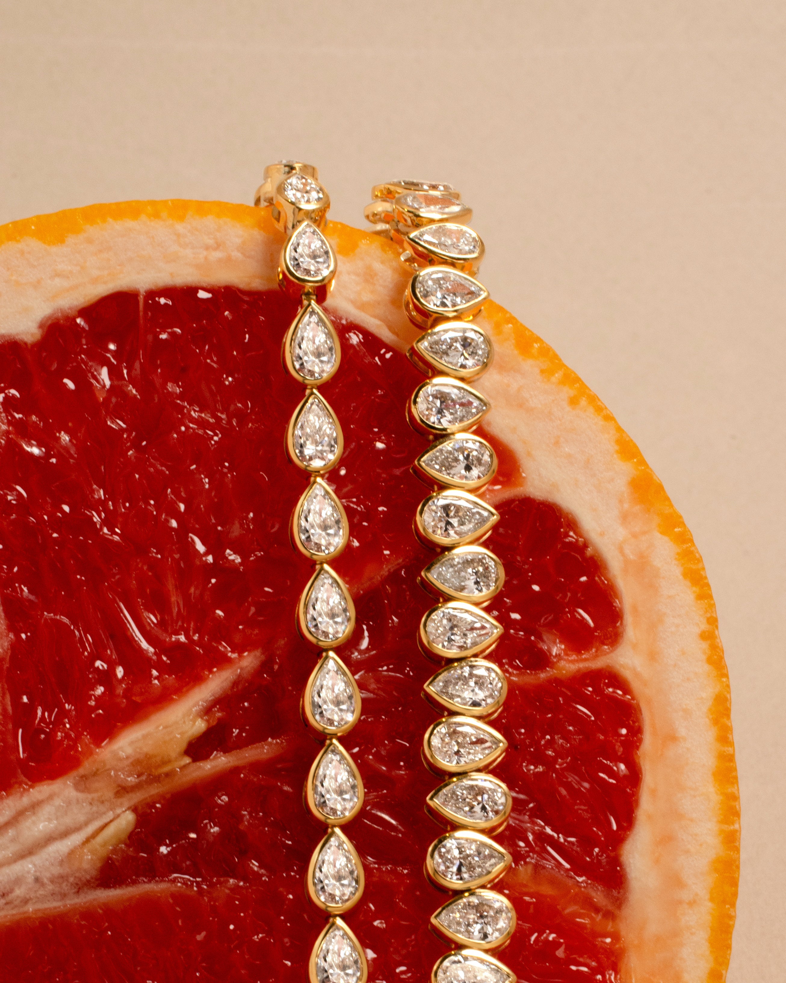 Gold tennis bracelets with bezel set pear shaped diamonds