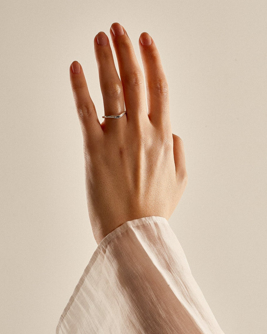 Gold curved wedding band on a hand