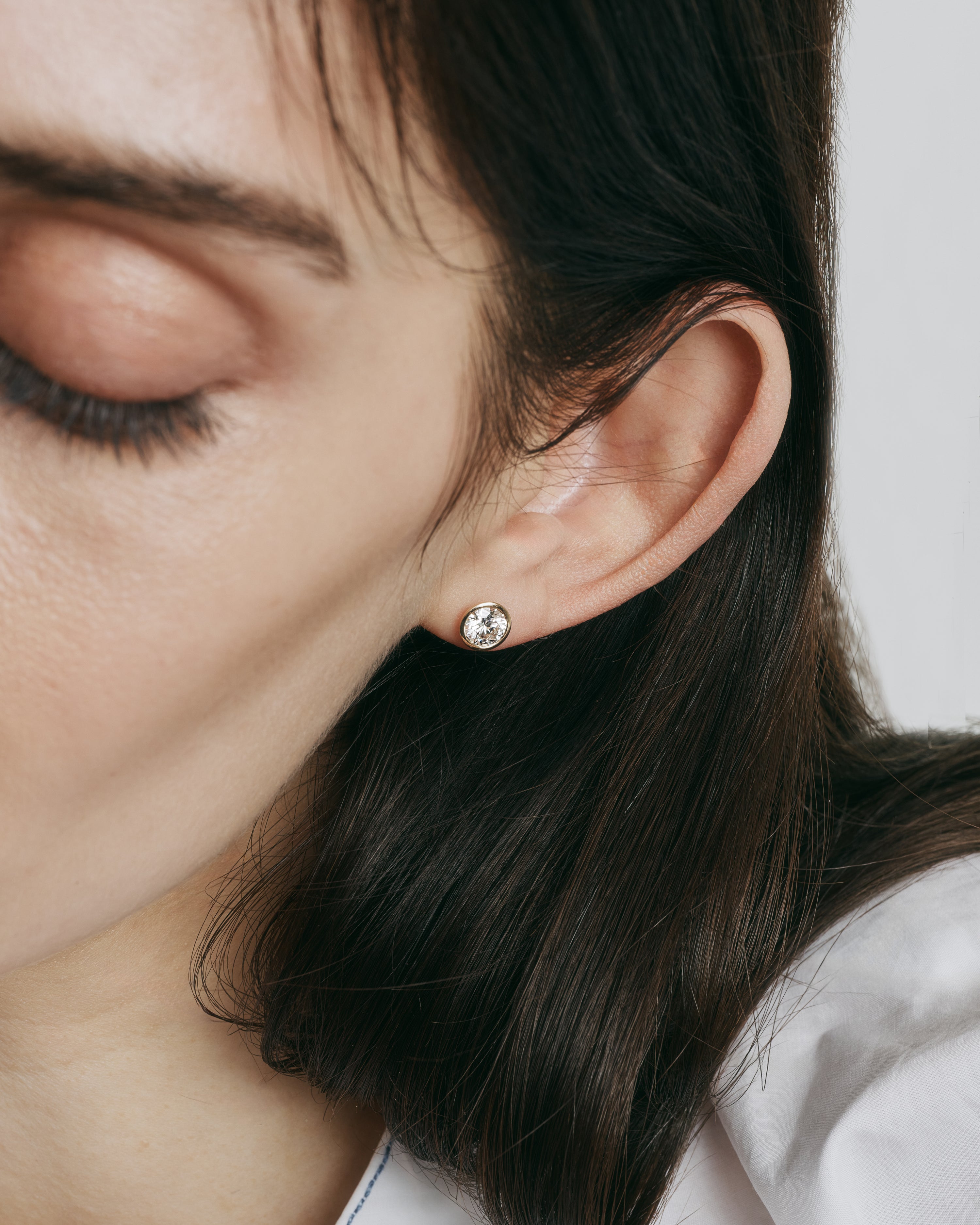 yellow gold bezel set earring stud with round brilliant diamond