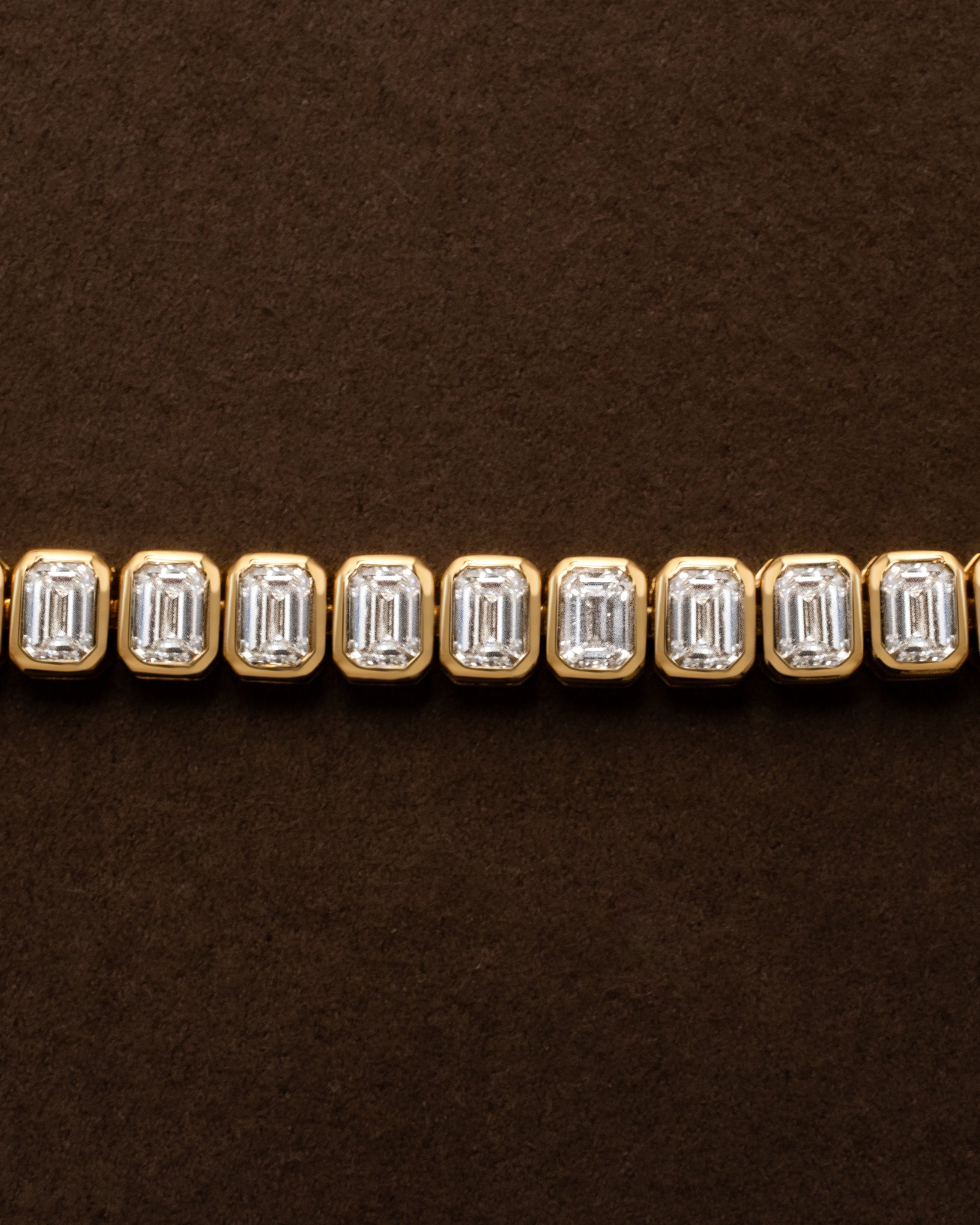 yellow gold tennis bracelet with bezel set emerald diamonds