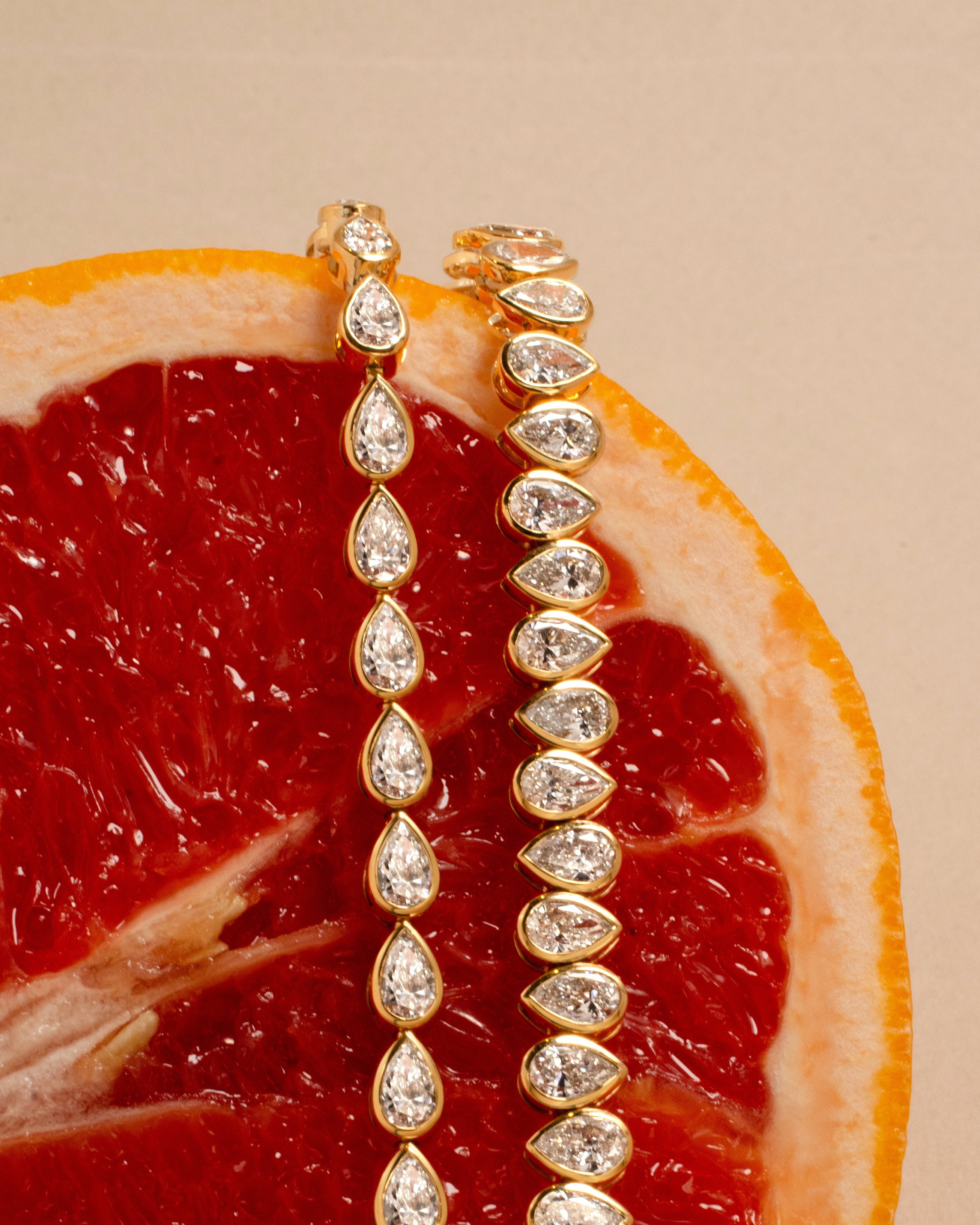 Gold tennis bracelets with bezel set pear shaped diamonds