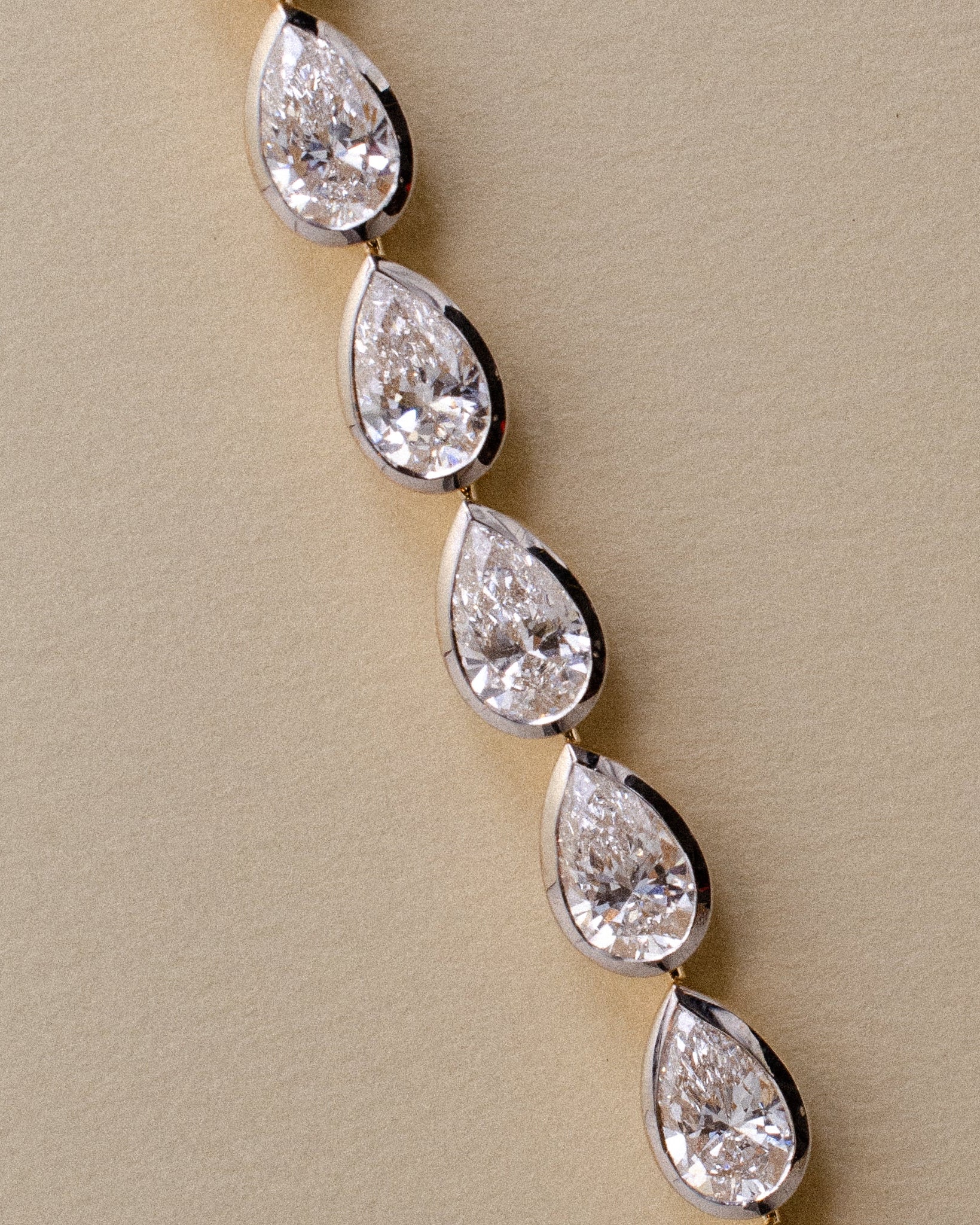 gold tennis bracelet with pear shaped bezel set diamonds