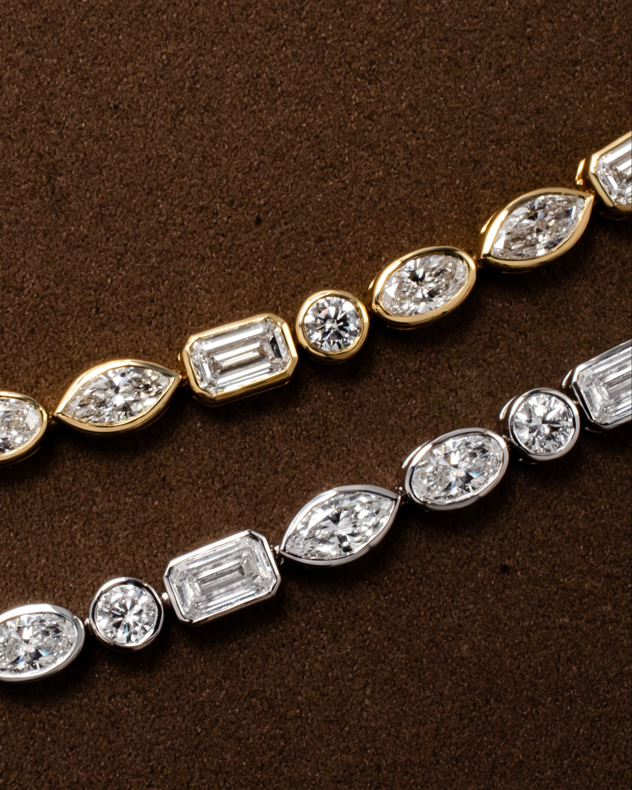 White gold and yellow tennis bracelets with bezel set diamonds round oval marquise emerald