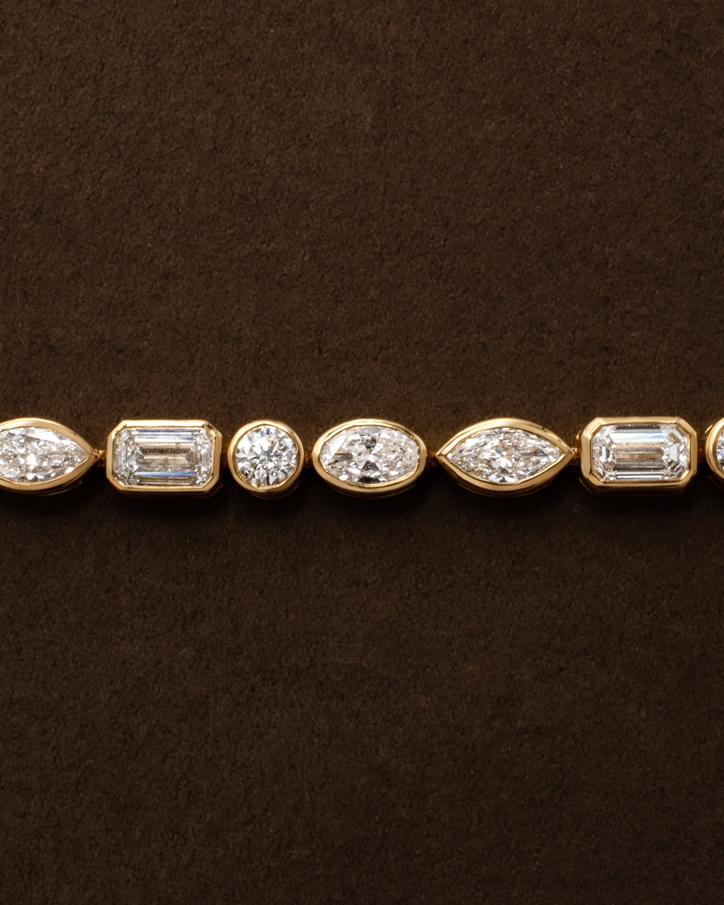 yellow gold tennis bracelet with bezel set round oval marquise emerald diamonds