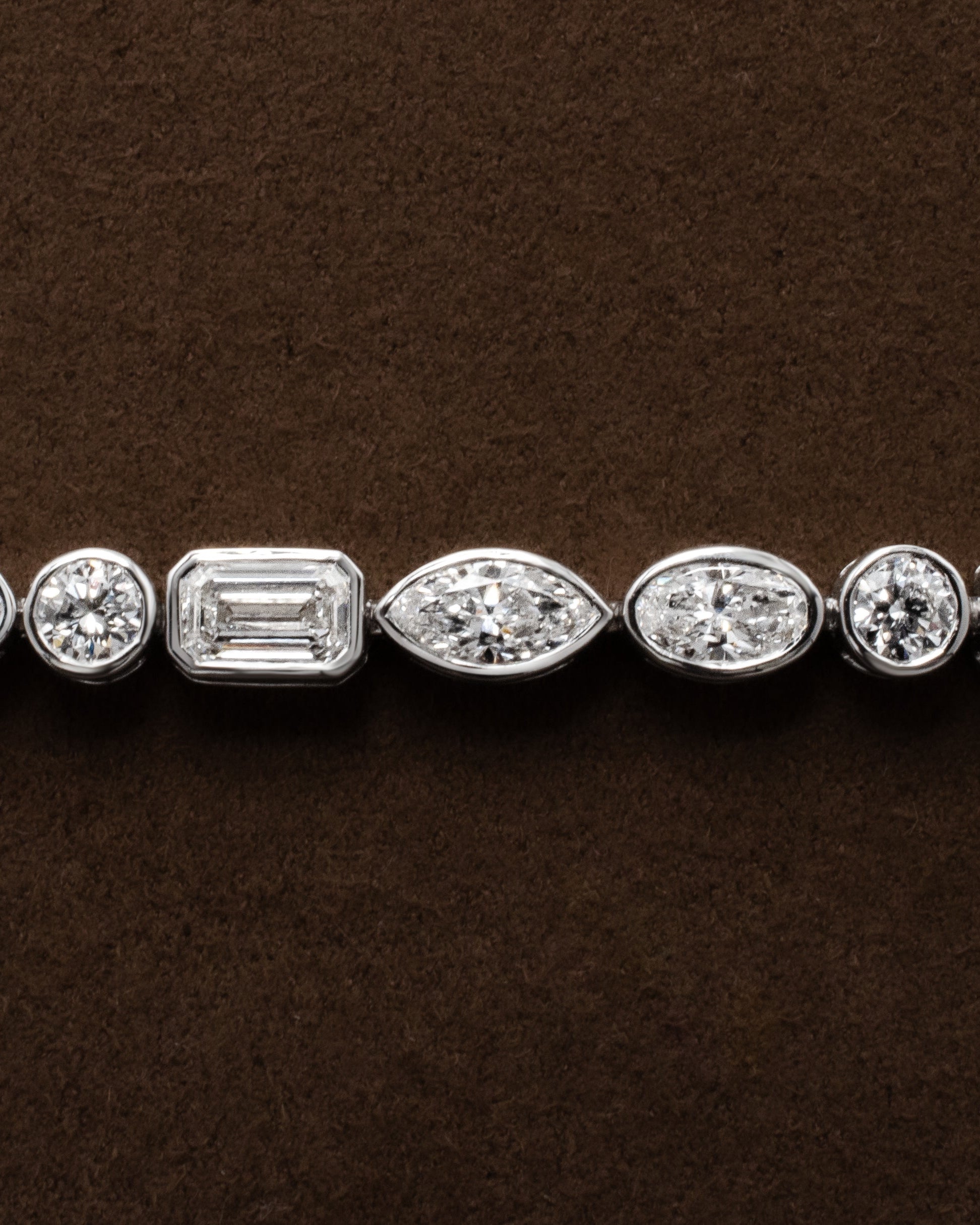 white gold tennis bracelet with bezel set round oval marquise emerald diamonds