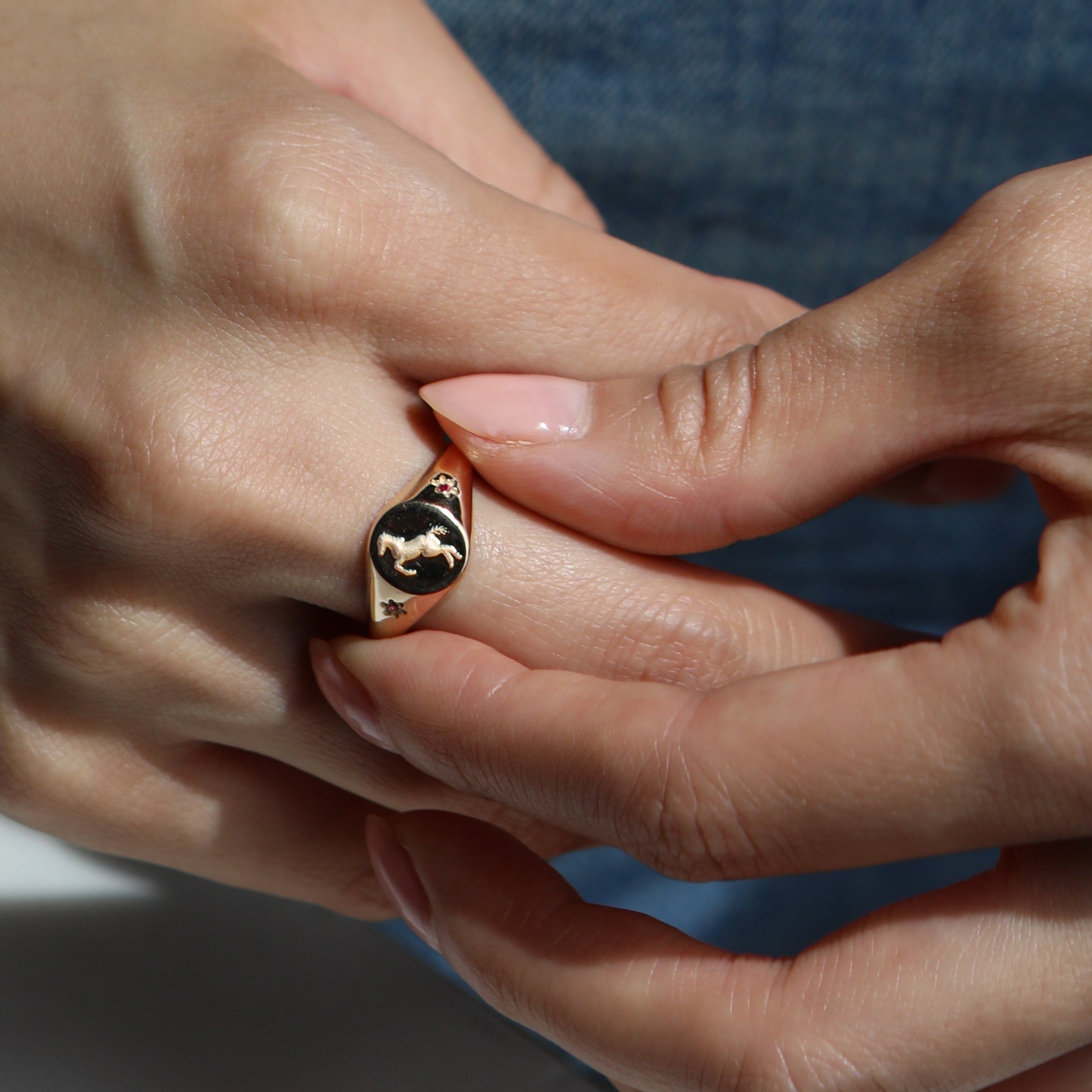 gold ring with pony engraving on hand 